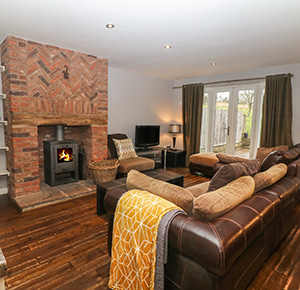 The homely interior of Heythrop in Staffordshire, with roaring fire, comfortable furnishings and a view into the garden
